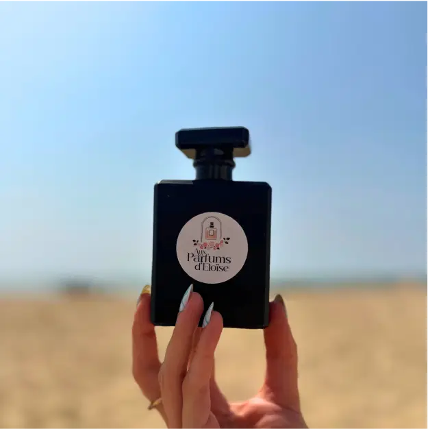 Photographie produit d’un flacon de parfum – Aux Parfums d’Eloïse à Châtelaillon-Plage Flacon de parfum Aux Parfums d’Eloïse photographié sur la plage de Châtelaillon-Plage pour une création de contenu réseaux sociaux