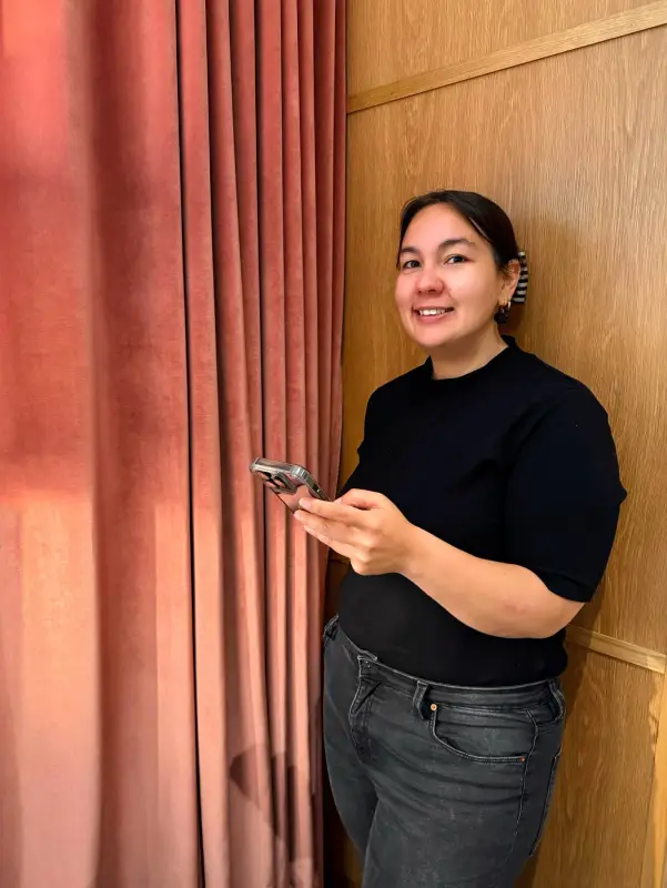 Ava, community manager freelance, tenant un téléphone portable pour illustrer son travail de gestion et animation des réseaux sociaux